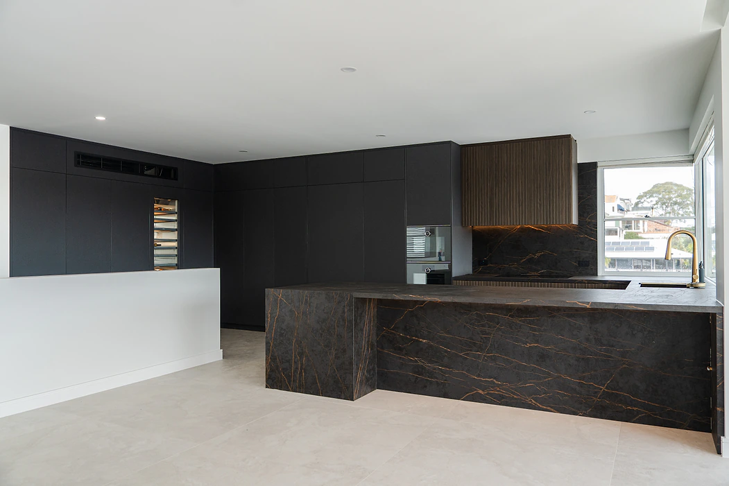 Kitchen ideas for your free consultation: black kitchen with dark stone island and fluted timber rangehood